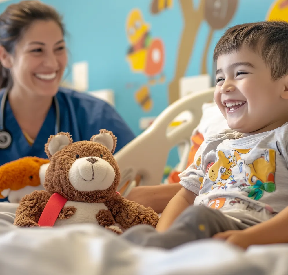 smiling kid with a nurse and stuffed animal